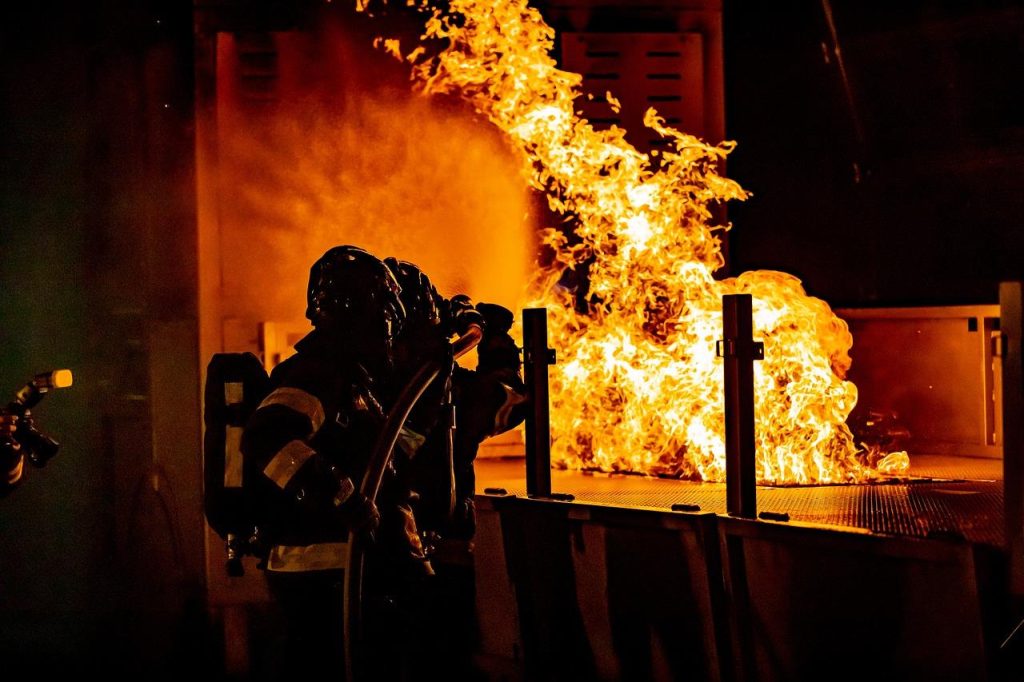 Brandweermensen interveniëren bij brand, illustreert belang van Brandklasse A2 NL voor veiligheid