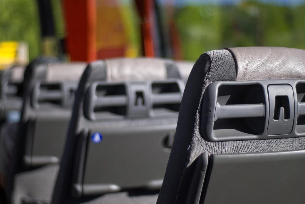 Groep vrienden en familie die samen in een moderne touringcar reizen voor een groepsuitje met comfort en veiligheid.